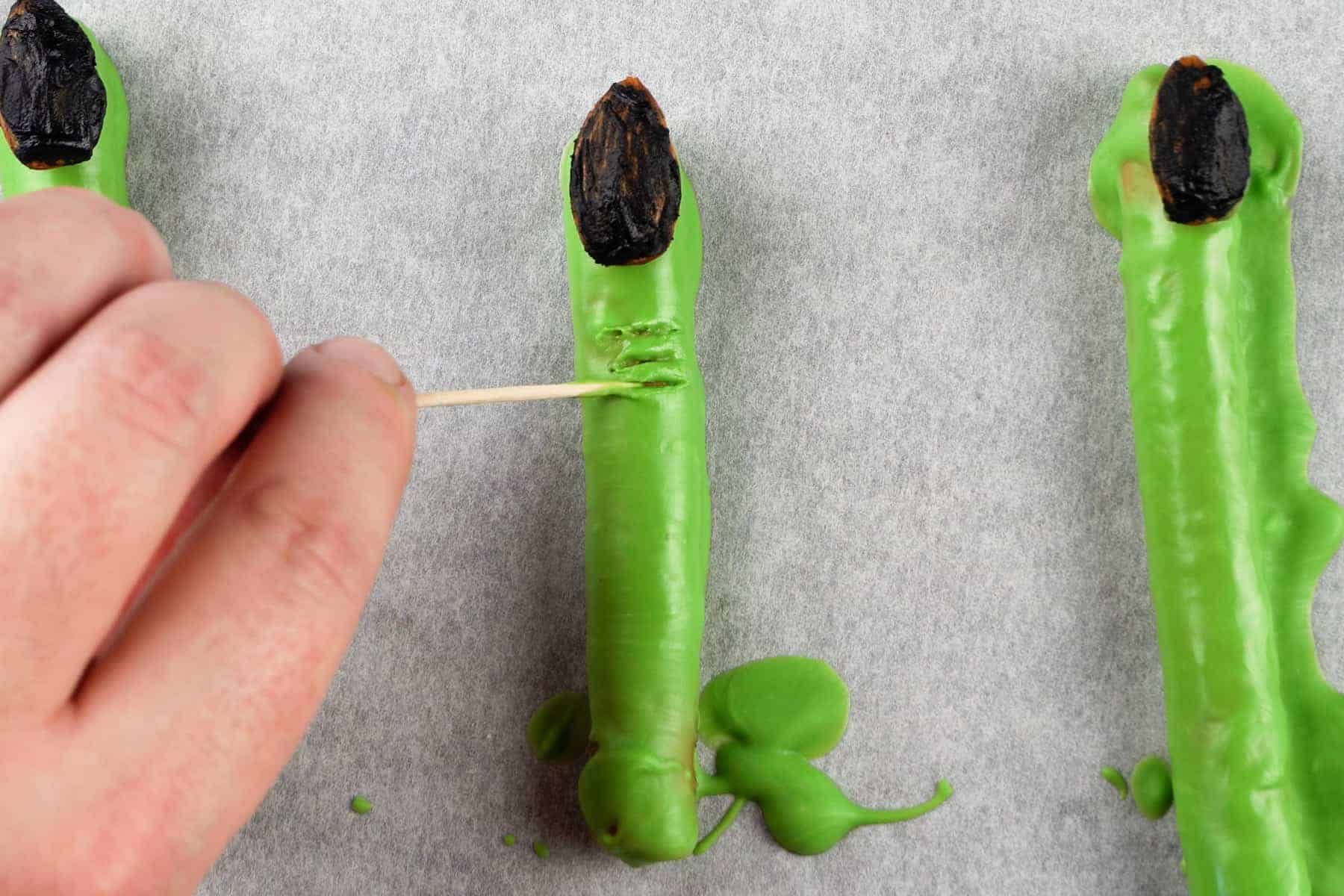 using a toothpick to create knuckle marks on witch finger.