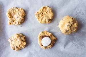 forming the marshmallow stuffed cookies - two halves of cookie dough, add chocolate and marshmallow then combine two halves