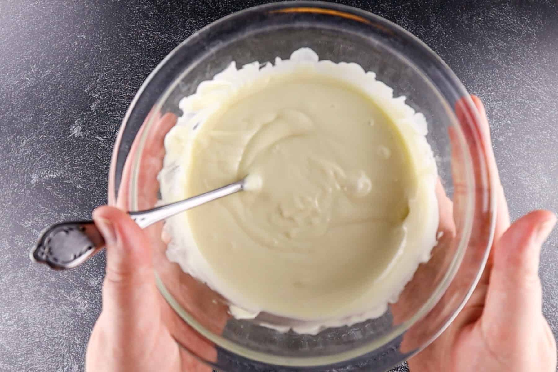 melted white chocolate chips in a clear glass bowl.