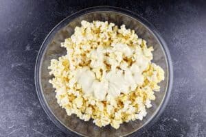 adding white chocolate to popcorn