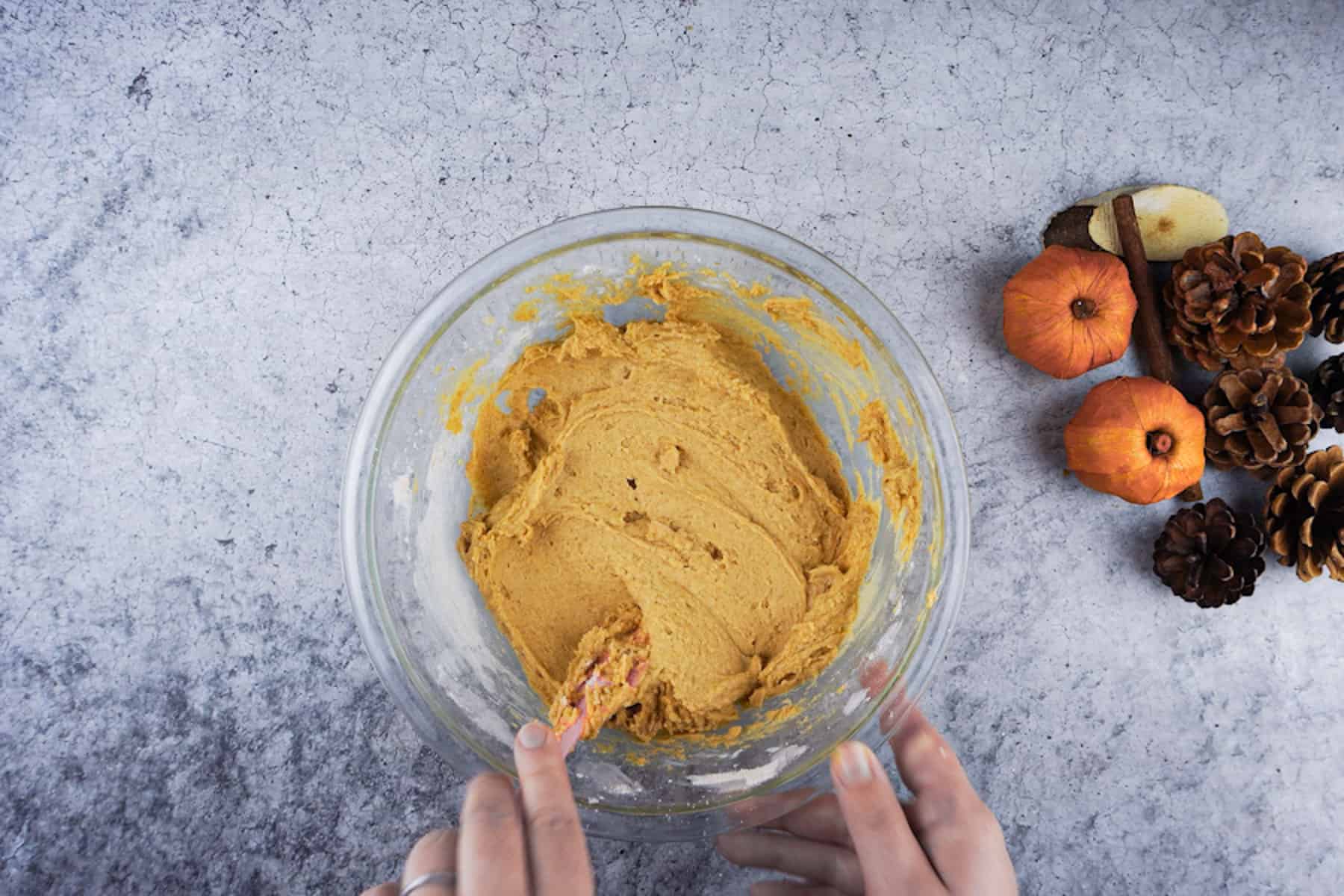 Pumpkin bread batter mixed in a clear glass bowl.