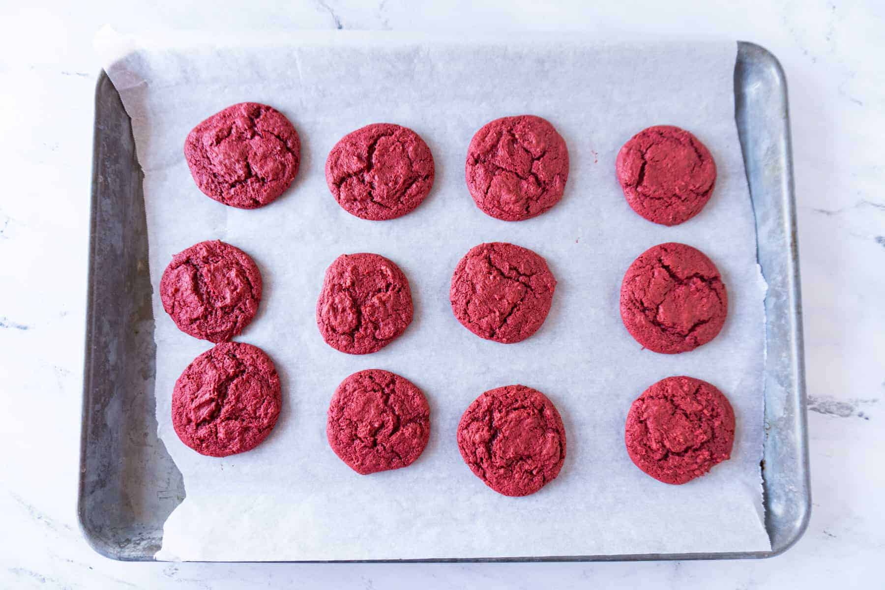 red velvet cake cookies baked on baking sheet.