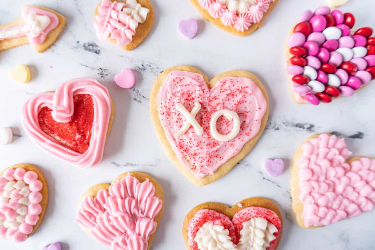 valentine cookies on marble with candies surrounding them