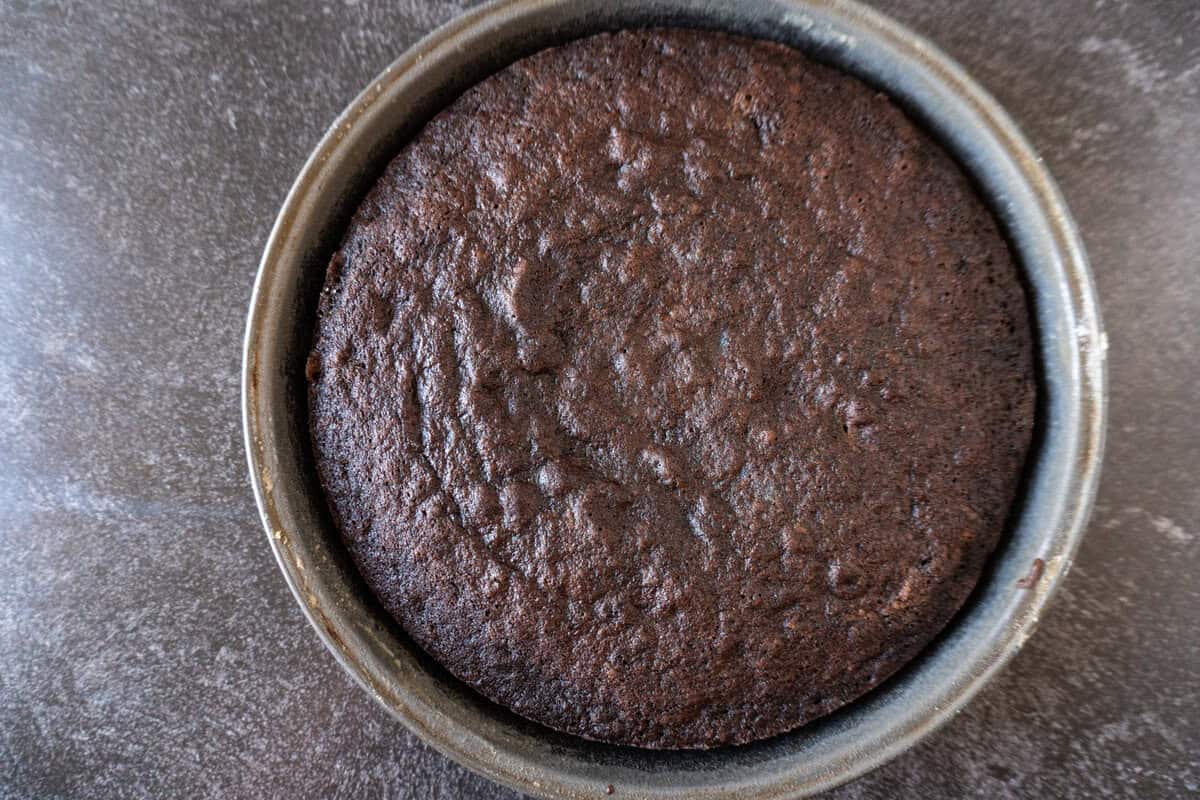 chocolate cake baked in round metal cake pan.