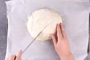 cutting slits into the top of the bread dough