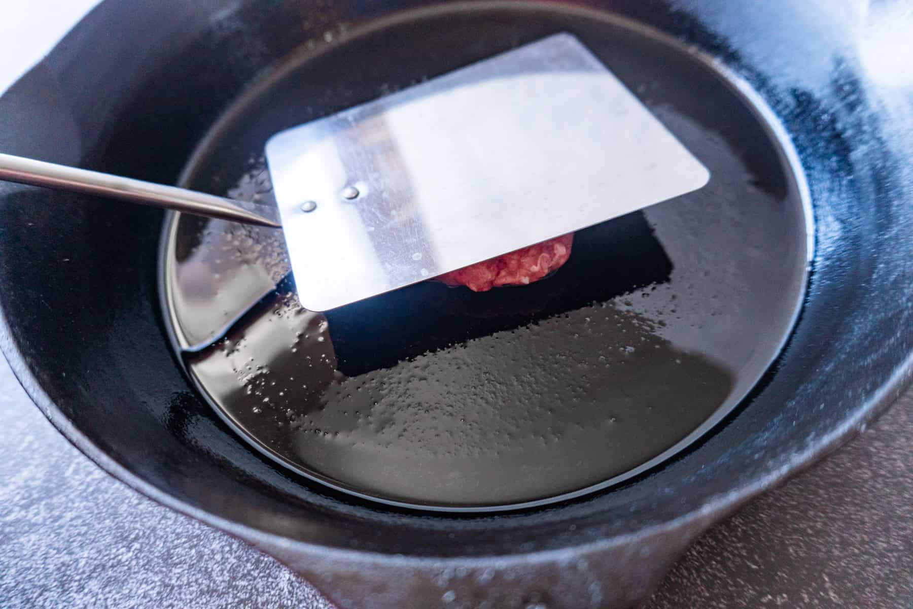 smashing a slider in cast iron pan
