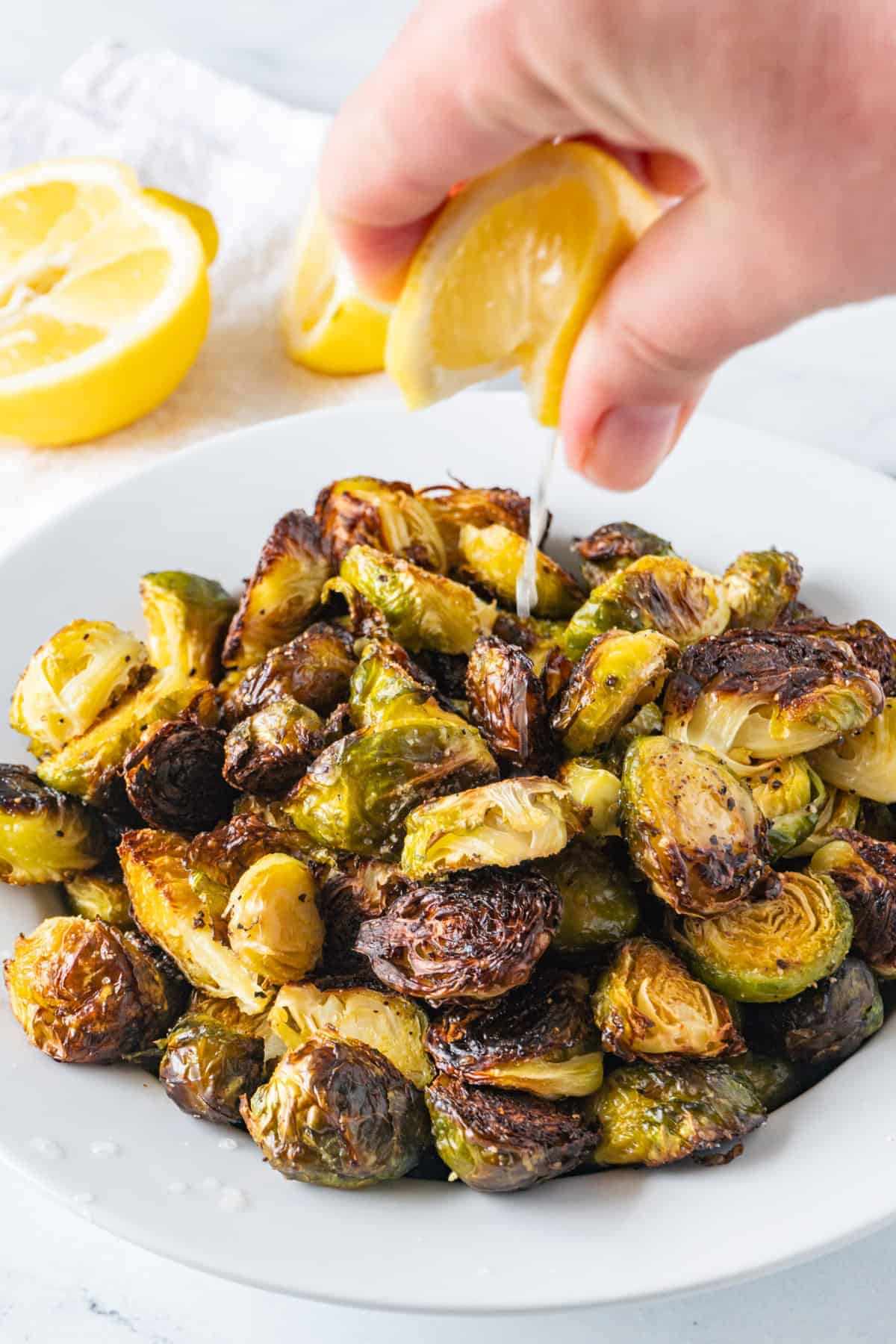 Oven Roasted Brussel Sprouts with lime juice being squeezed onto them