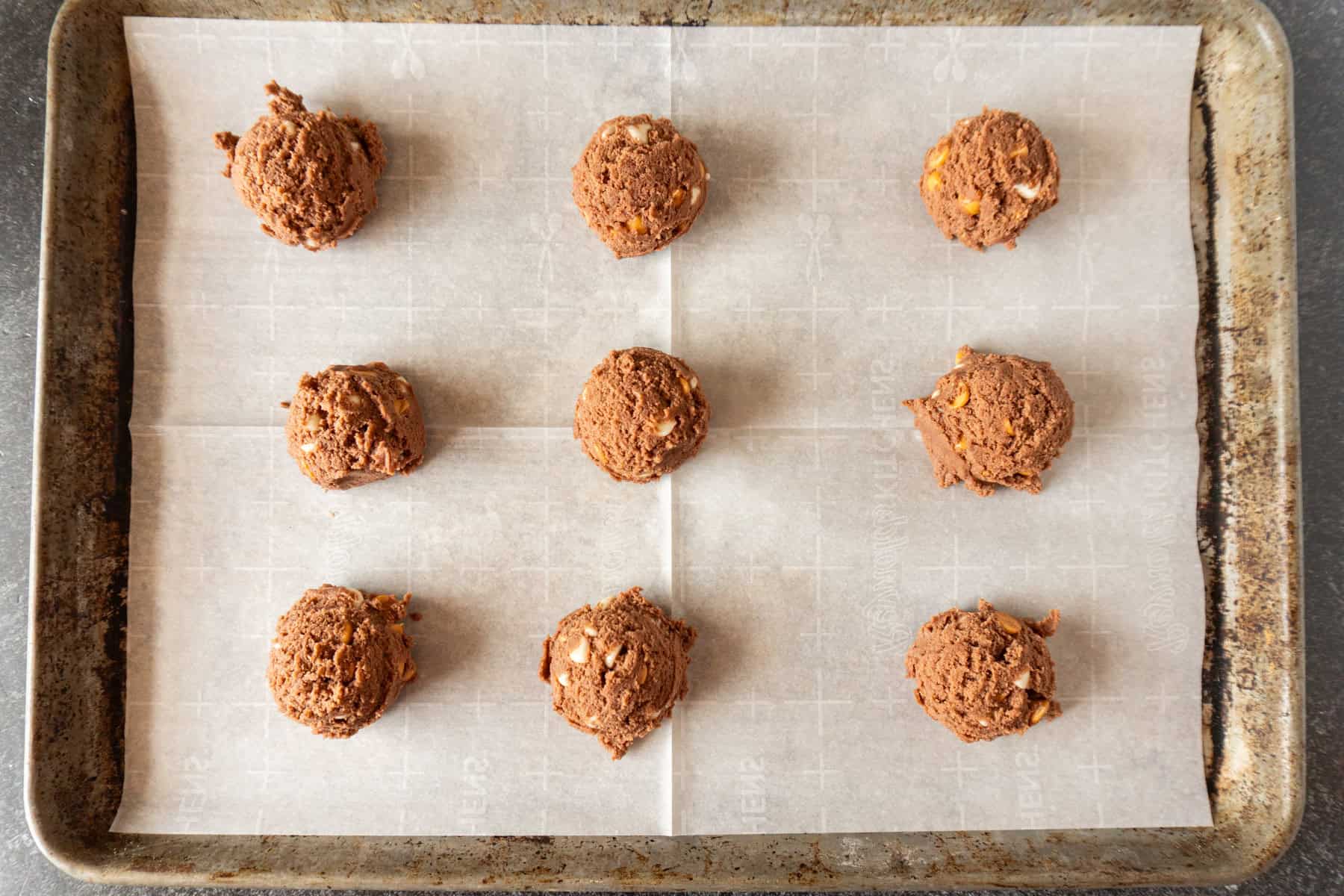 cookie dough scooped onto parchment lined baking sheet.