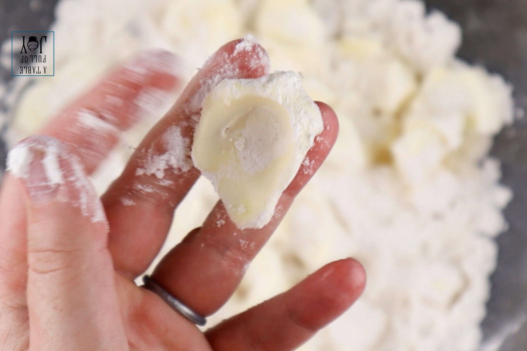 Smashing a chunk of butter in the flour mixture.