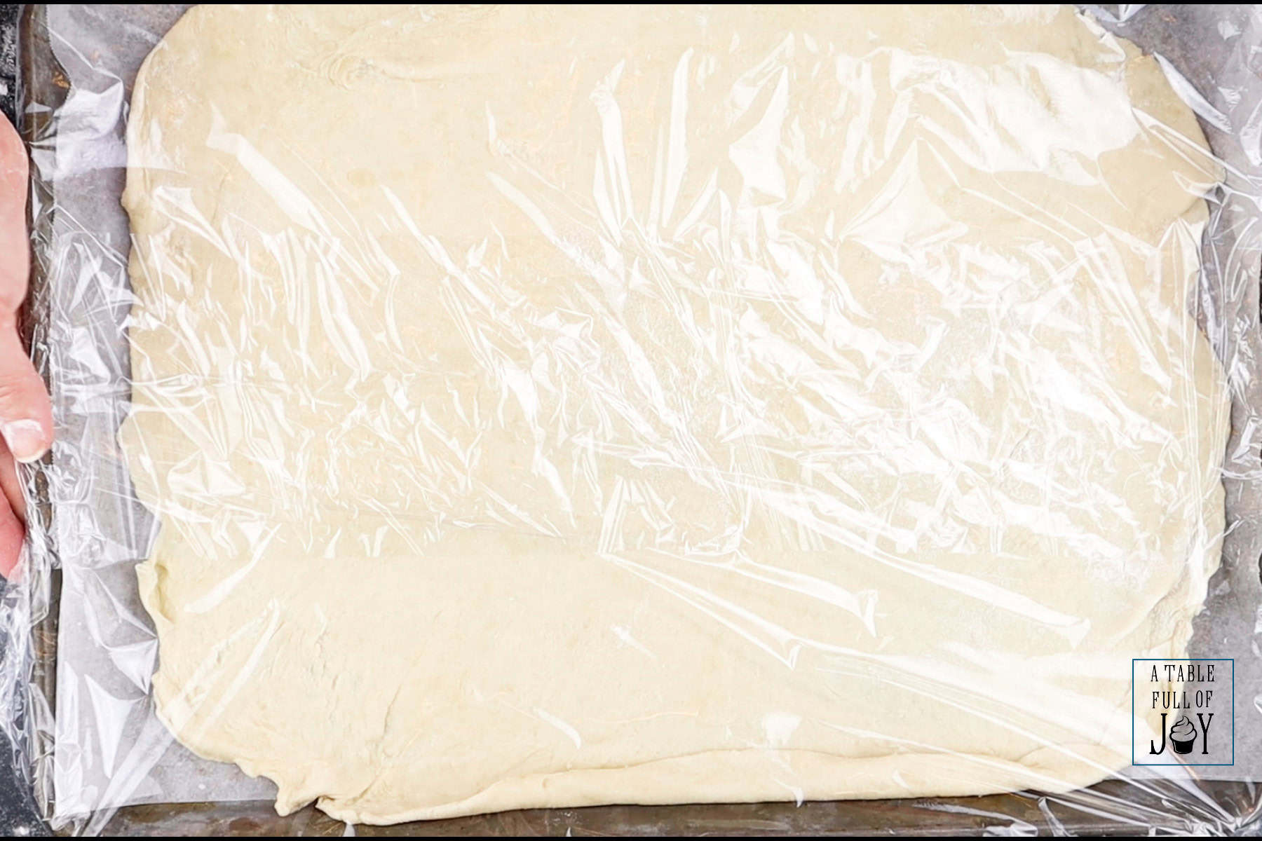 Pie dough rolled out in to a rectangle, covered, and ready to be refirgerated.