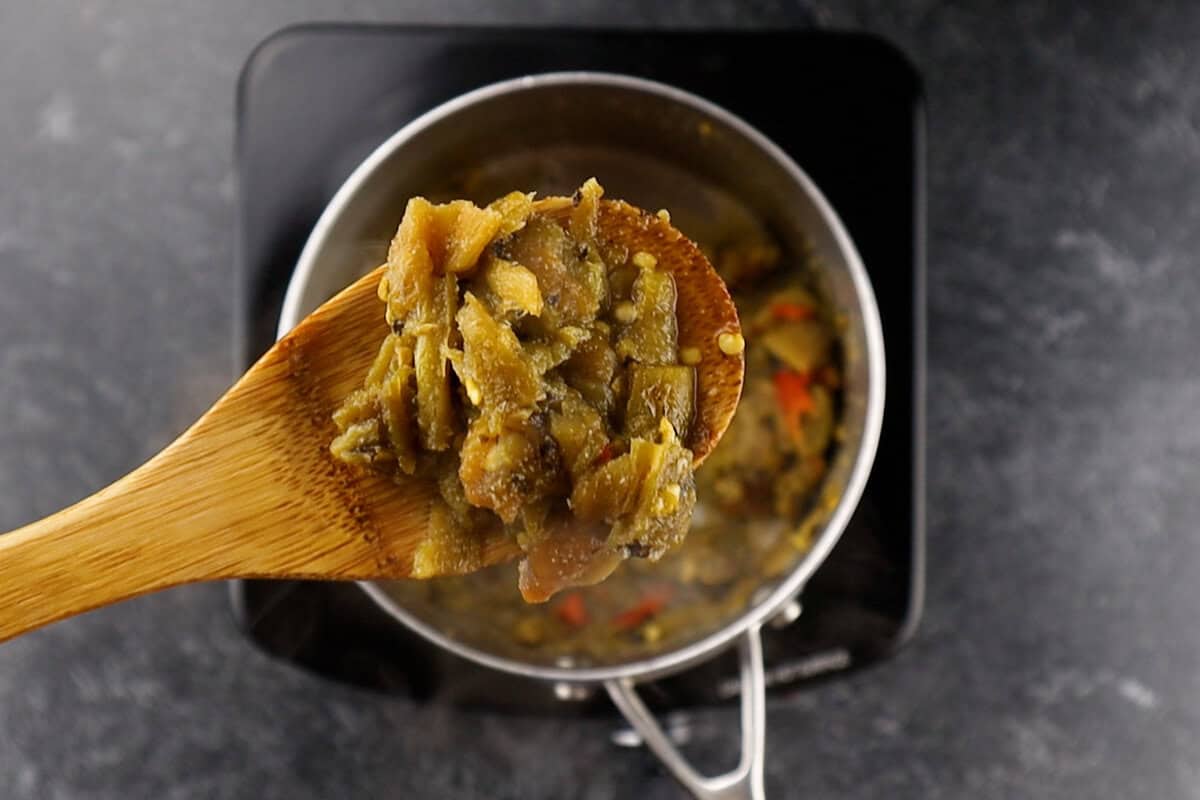 green chile sauce on wooden spoon.