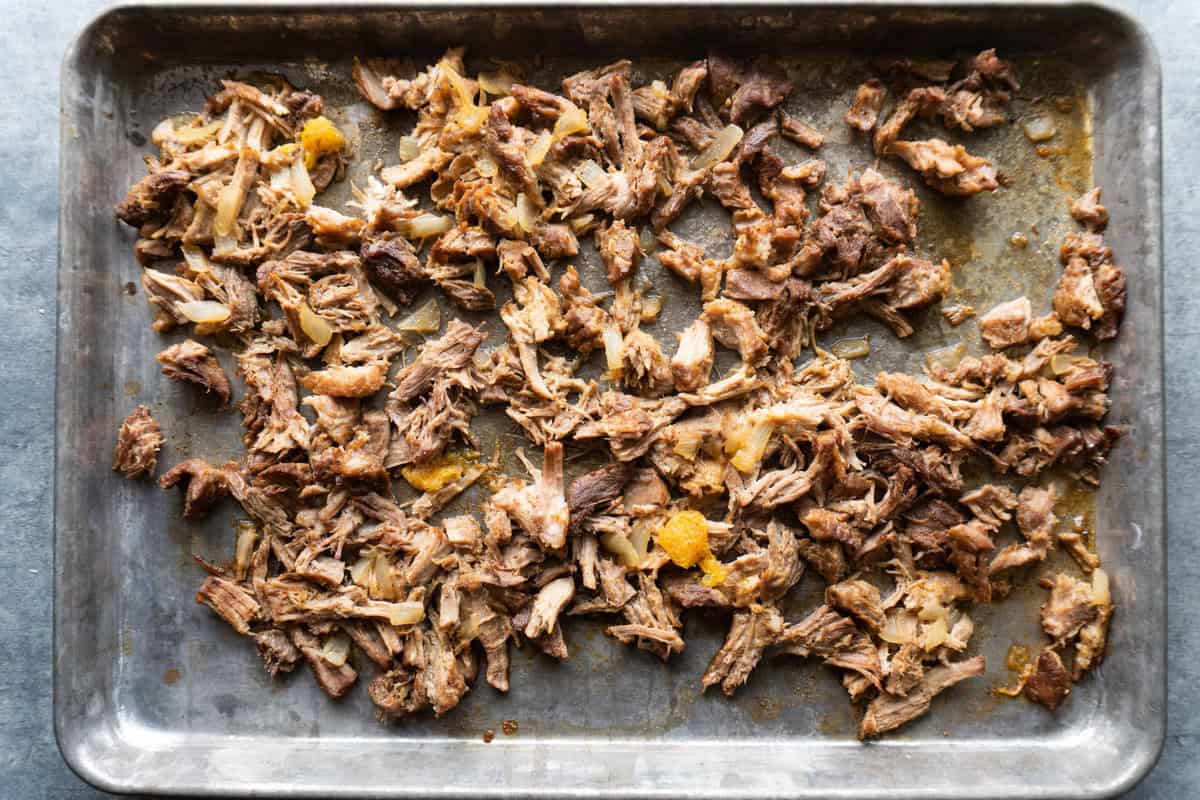 shredded pork carnitas on a baking sheet. 