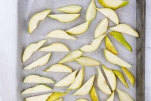 Pear slices spread out on baking sheet