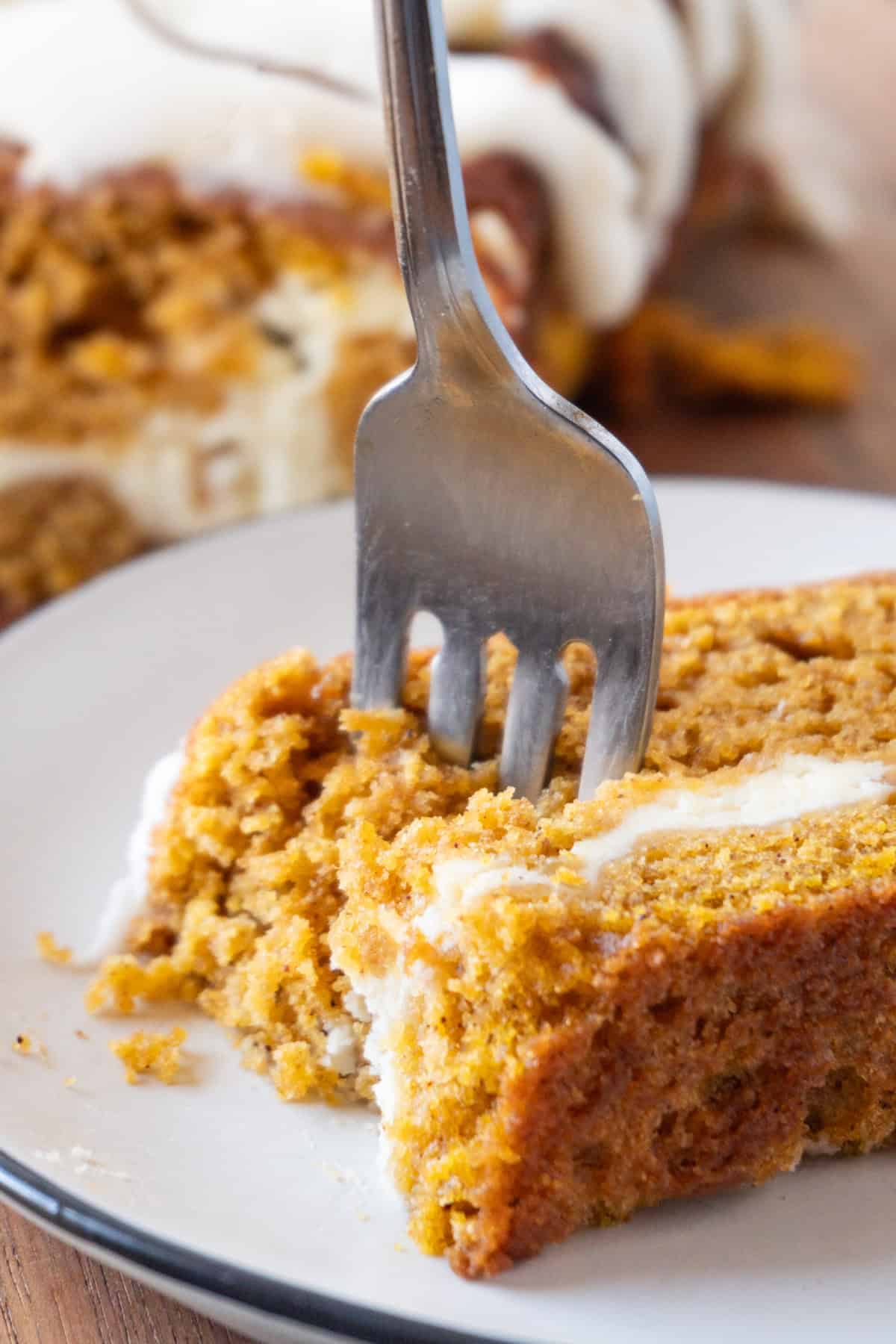 sticking a fork into a slice of pumpkin bread.