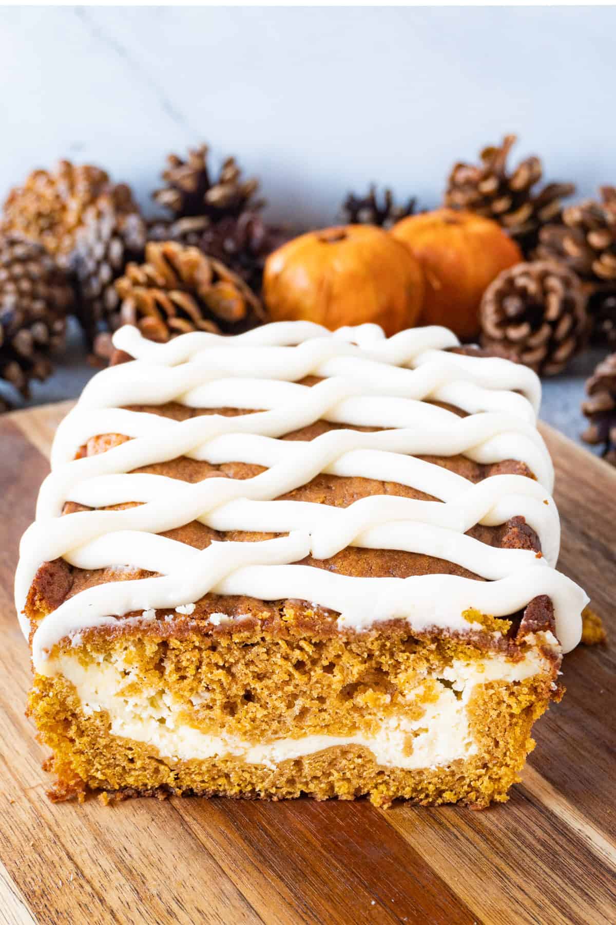 Pumpkin Bread with cream cheese frosting, with the end cut off of the loaf to show the cream cheese center.