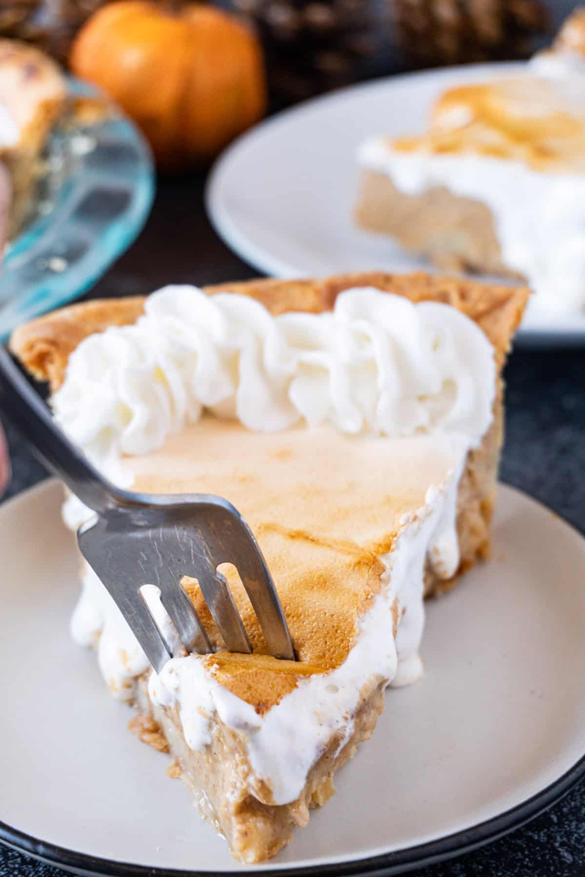 Sweet Potato Pie slice on a white plate with a fork, taking a piece out of the pie.