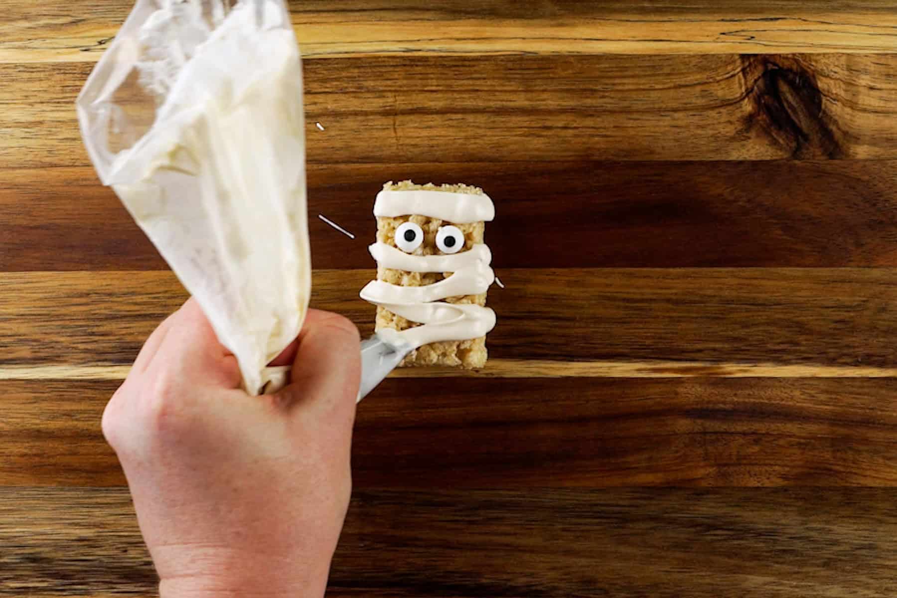 Rice Krispy rectangle decorated to look like a mummy using piped on white candy melts.