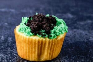 adding crushed oreos on top of grass frosting