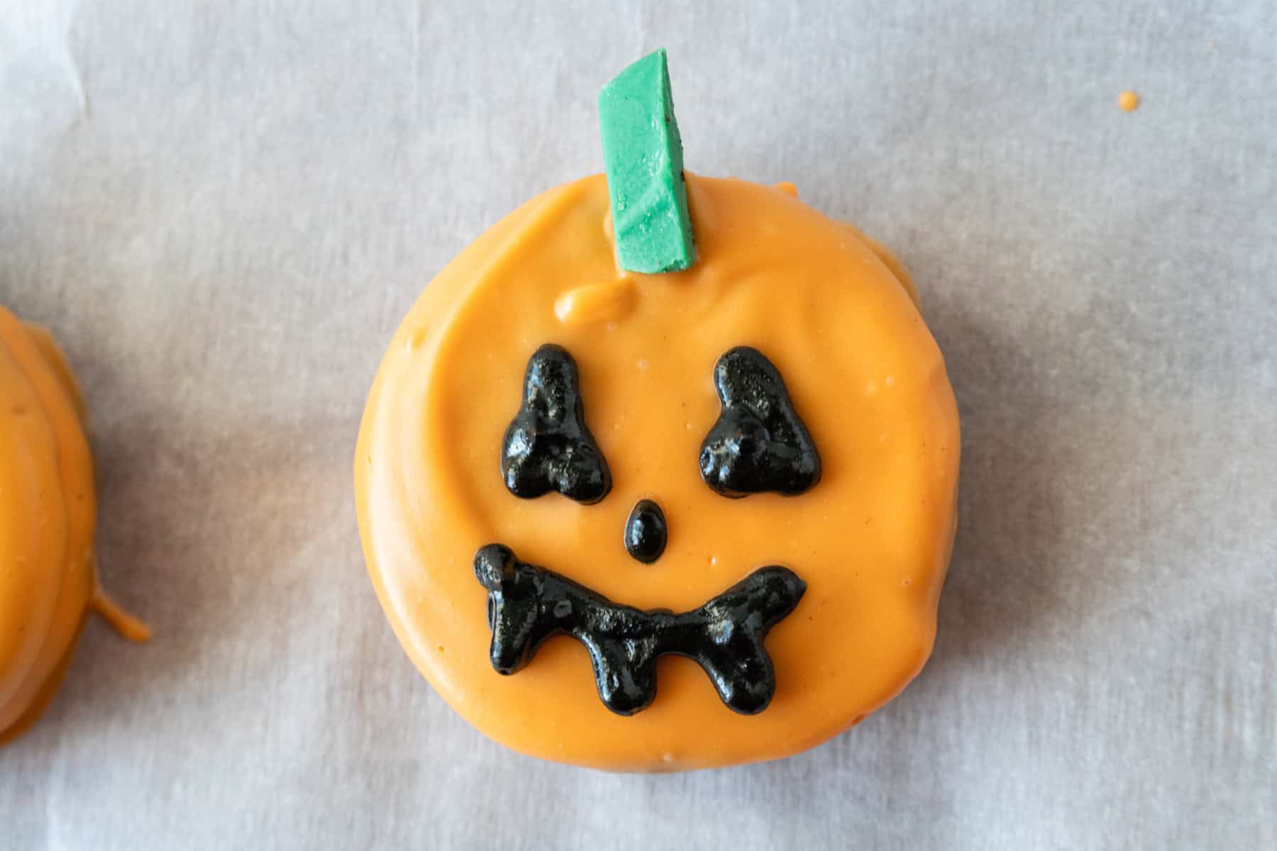 Oreo dipped in orange candy melts. decorated to look like a Jack-O-Lantern.