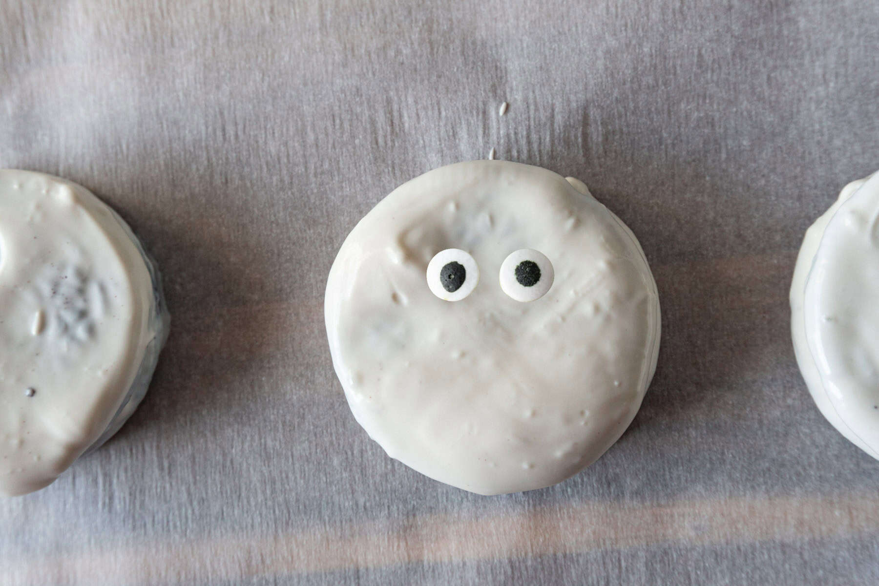 Oreo covered in white candy melts with candy eyes pressed on.