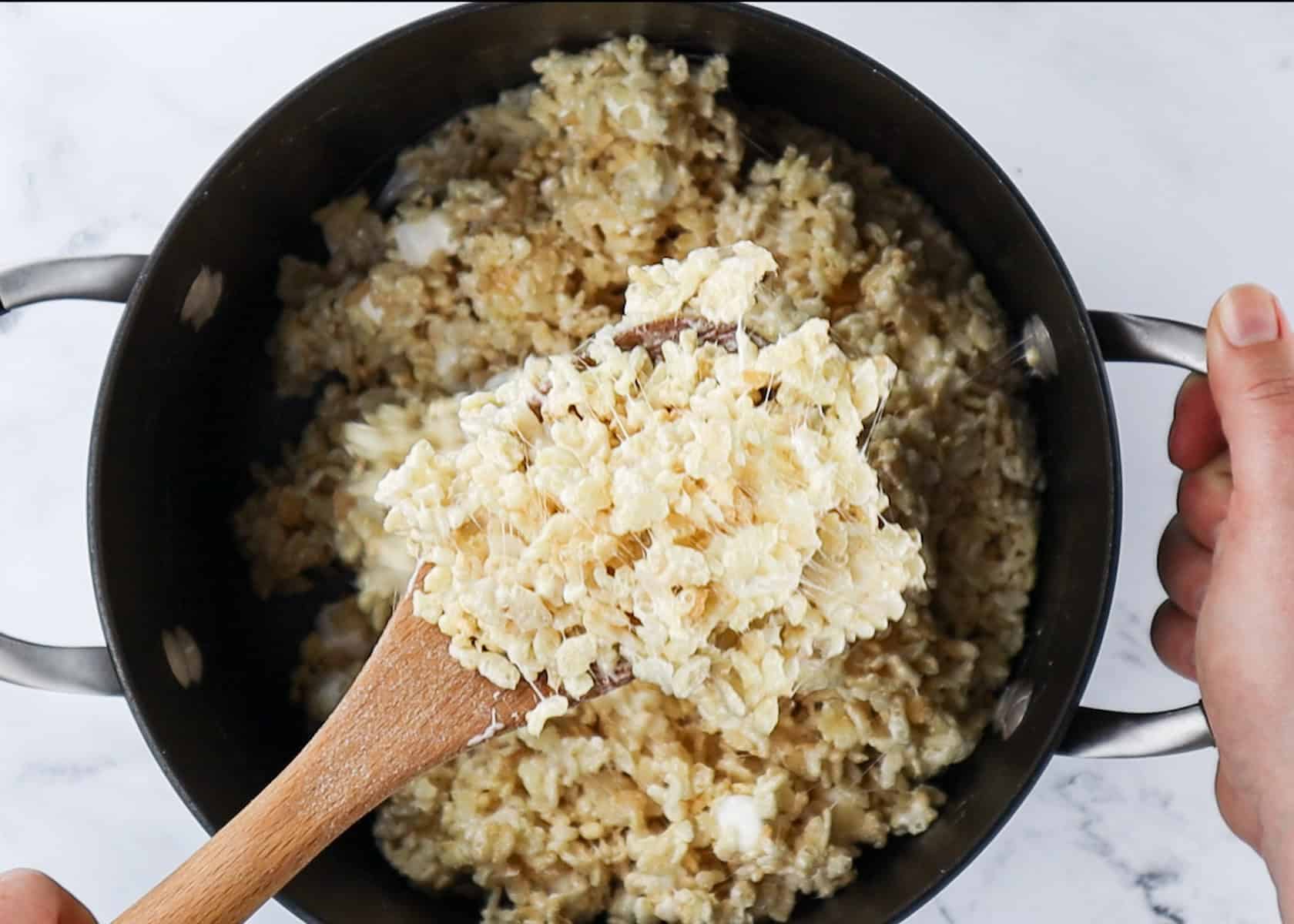 rice krispie cereal stirred into marshmallow mixture in pot.