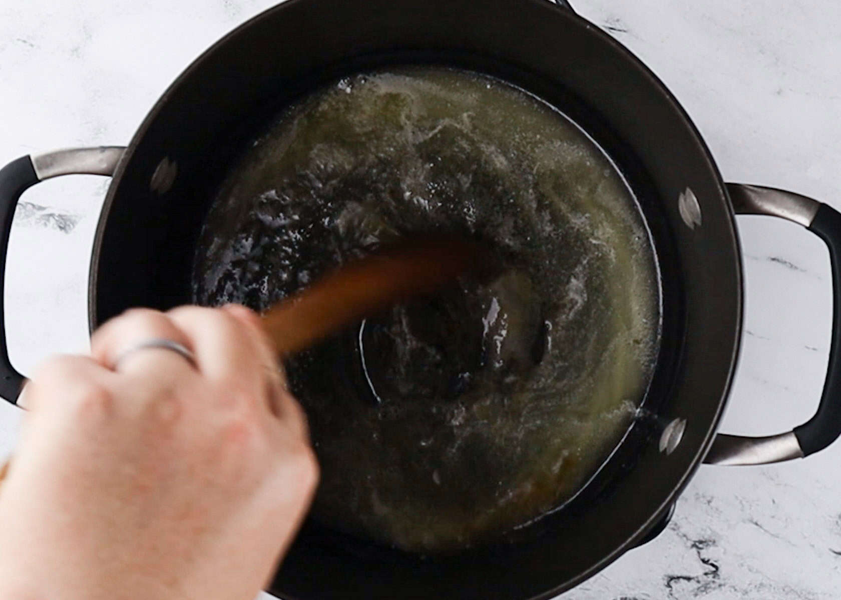 butter melted in a black stove pot.