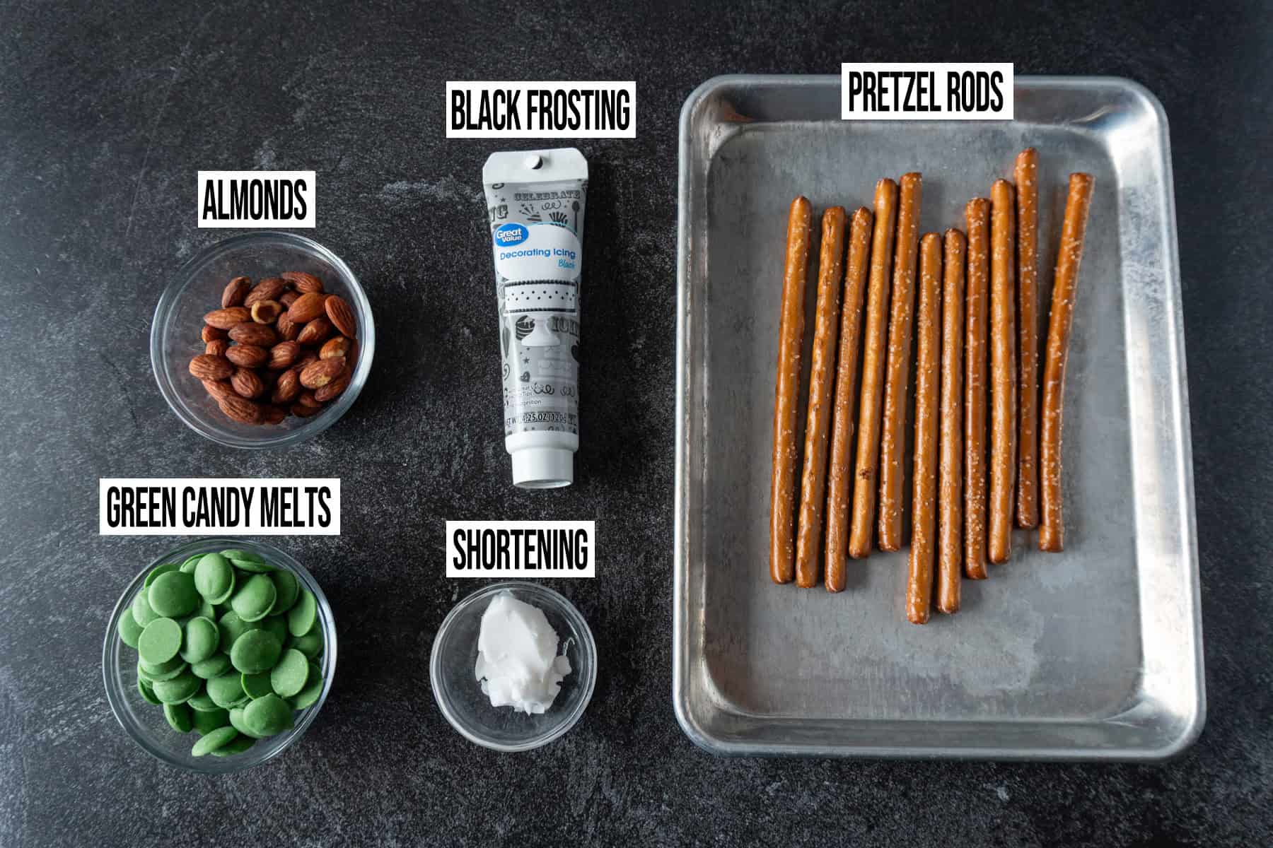 Witches Fingers Pretzel Rods ingredients in individual bowls and labeled.