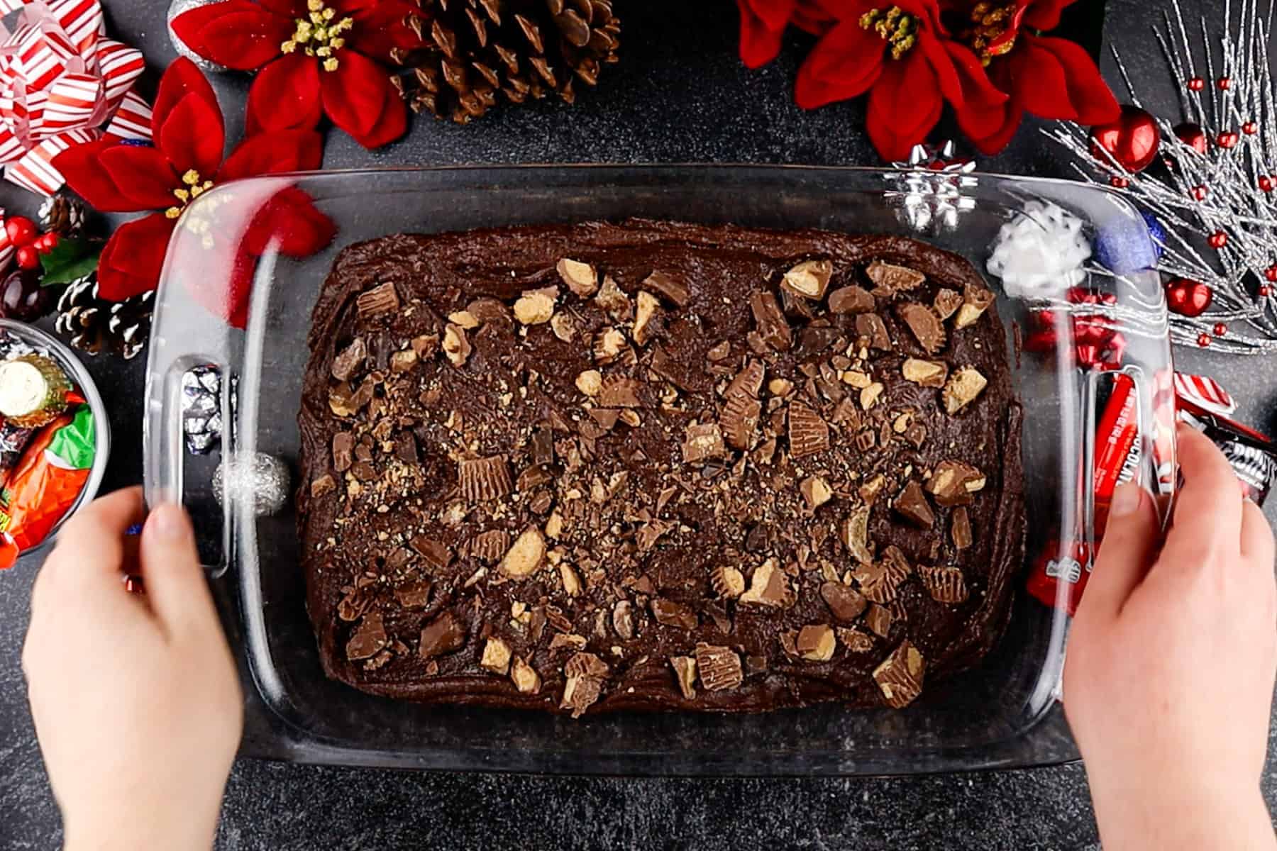 Brownie batter in a baking dish, with candy pieces sprinkled on top.