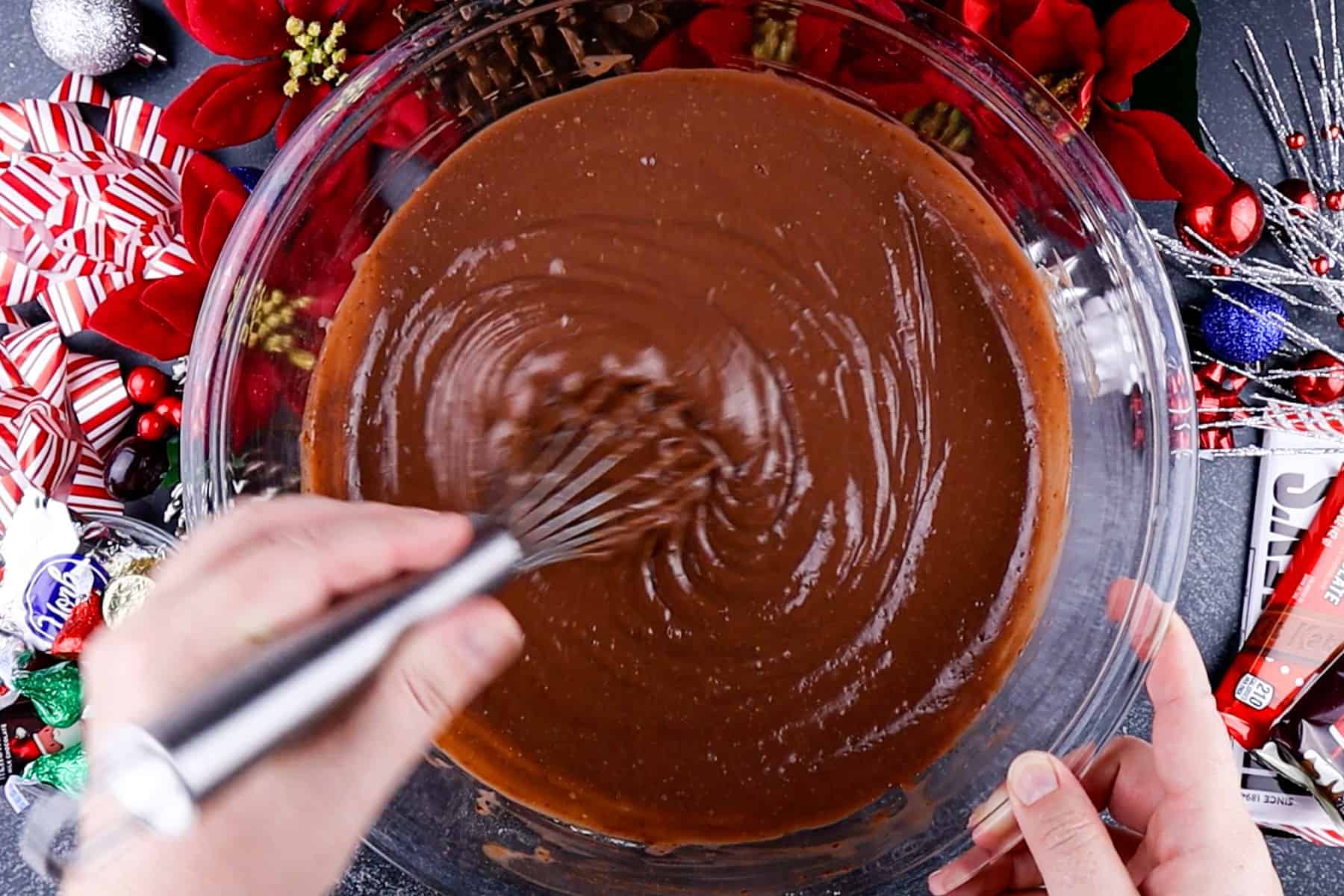 whisking chocolate pudding in glass bowl.