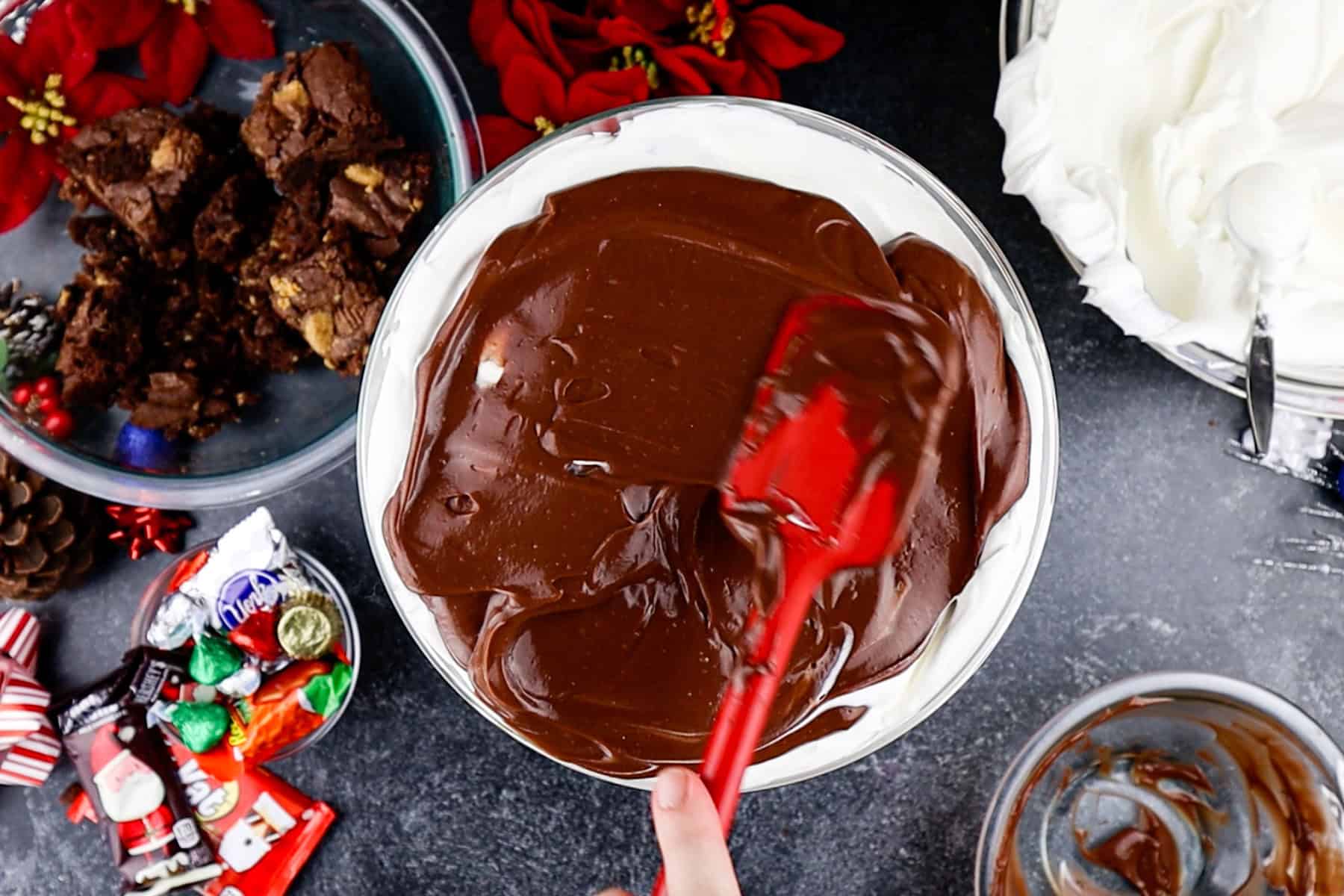 adding a layer of pudding over the whipped cream in the trifle dish.
