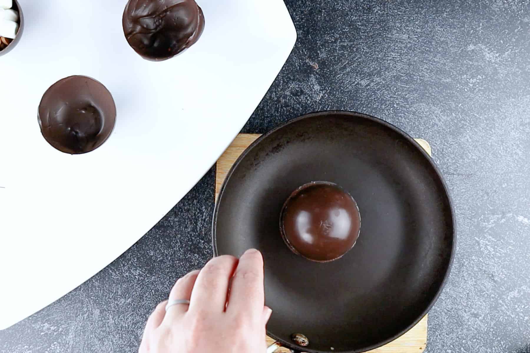 melting the rim of a chocolate shell in a warm fry pan.