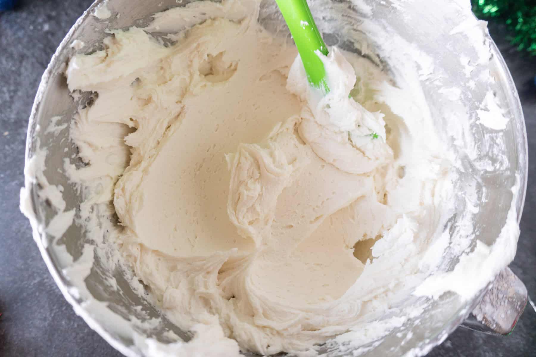 White buttercream frosting in metal mixing bowl.
