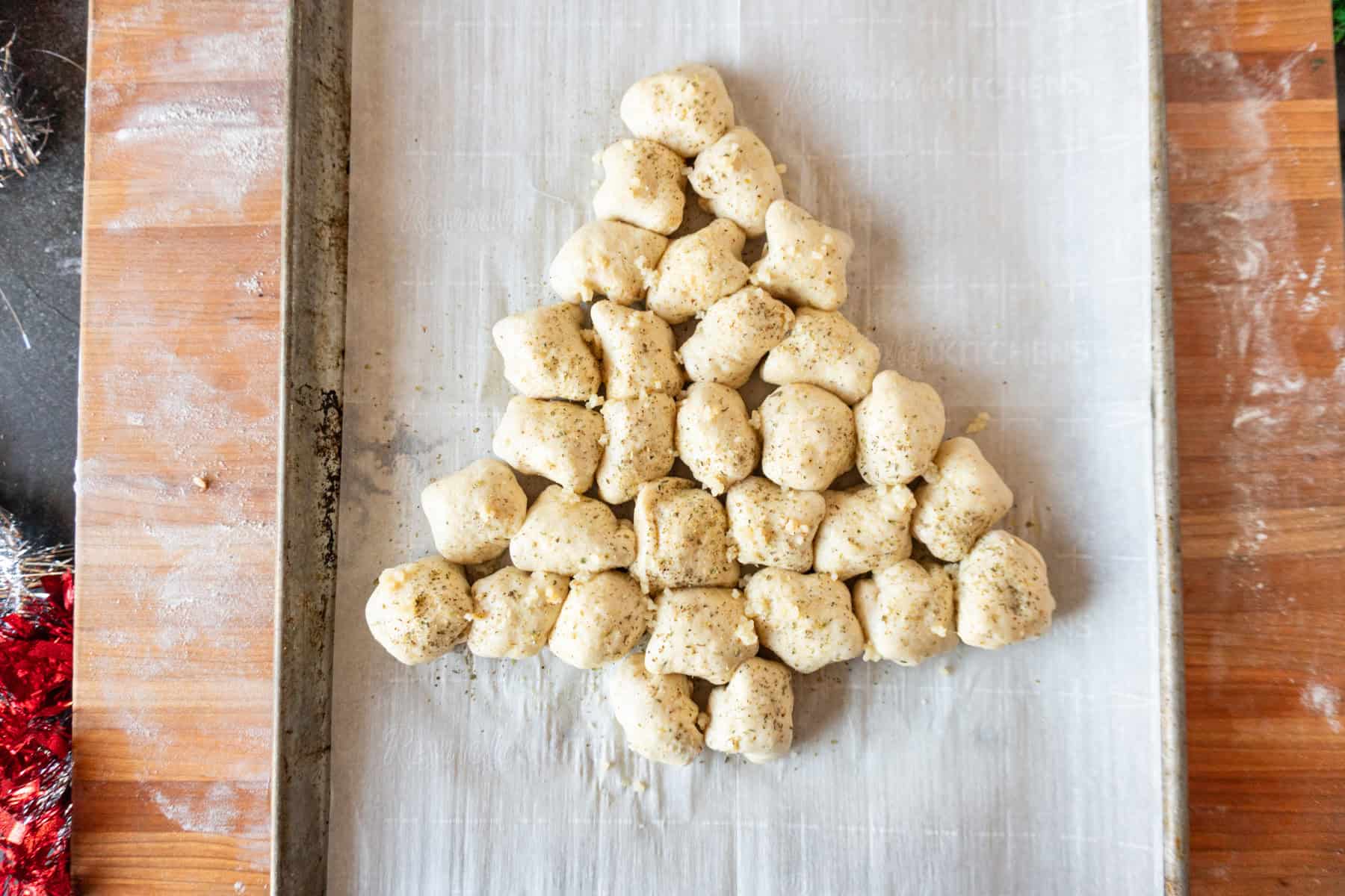 christmas appetizer before baking, brushed with egg wash, on baking sheet.