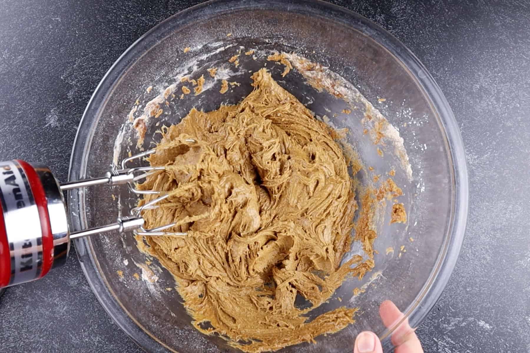 Gingerbread crinkle cookie dough mixed in a glass bowl.