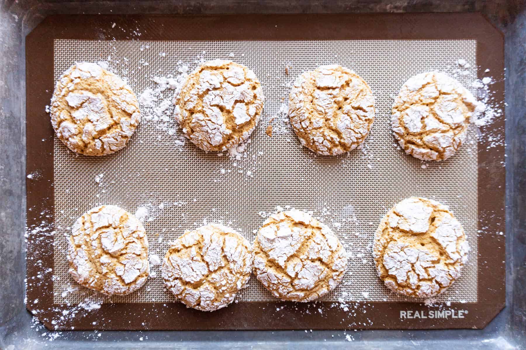 gingerbread crinkle cookies baked on a baking sheet.