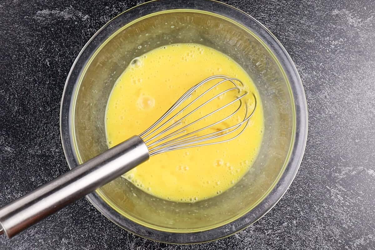 whisked eggs in clear glass bowl.