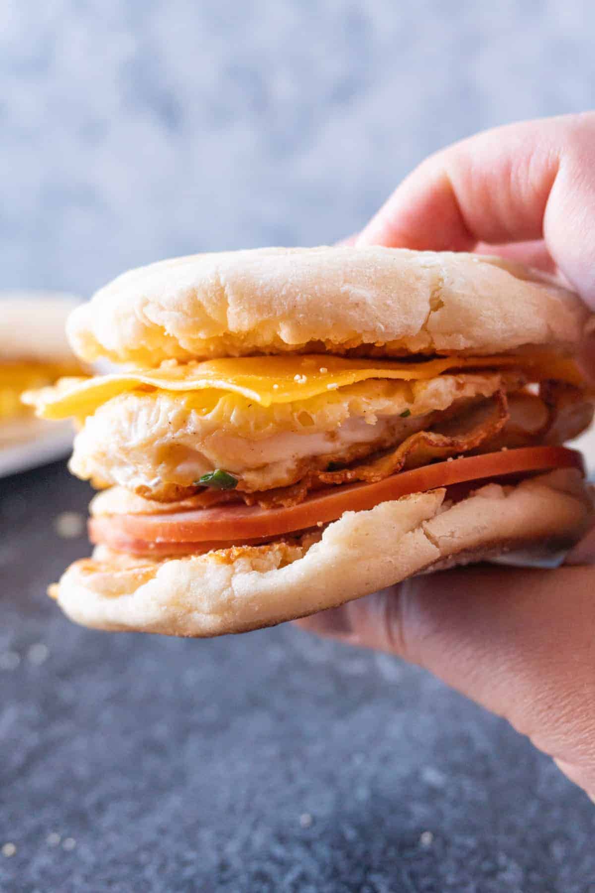 holding a fried egg breakfast sandwich