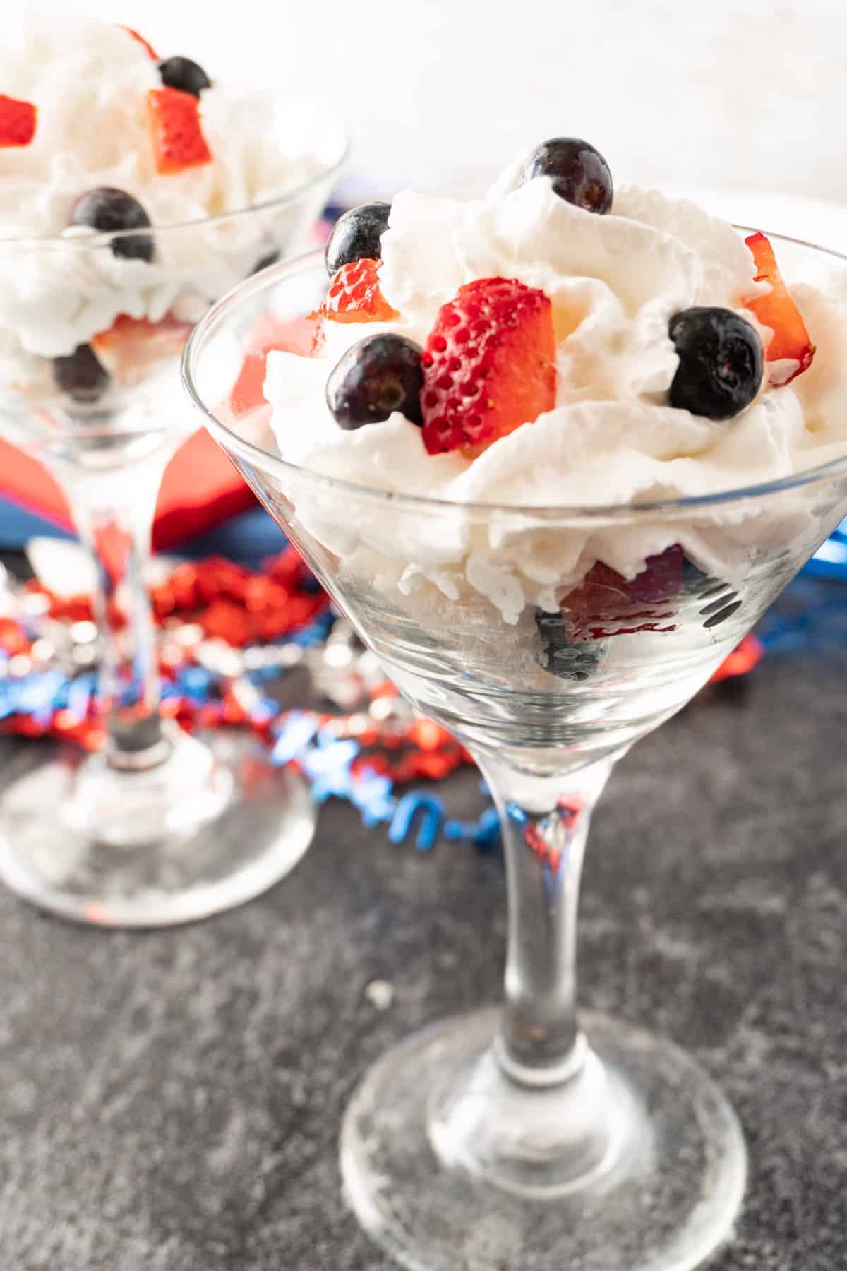 angel food cake, whipped cream, and berries in martini glass