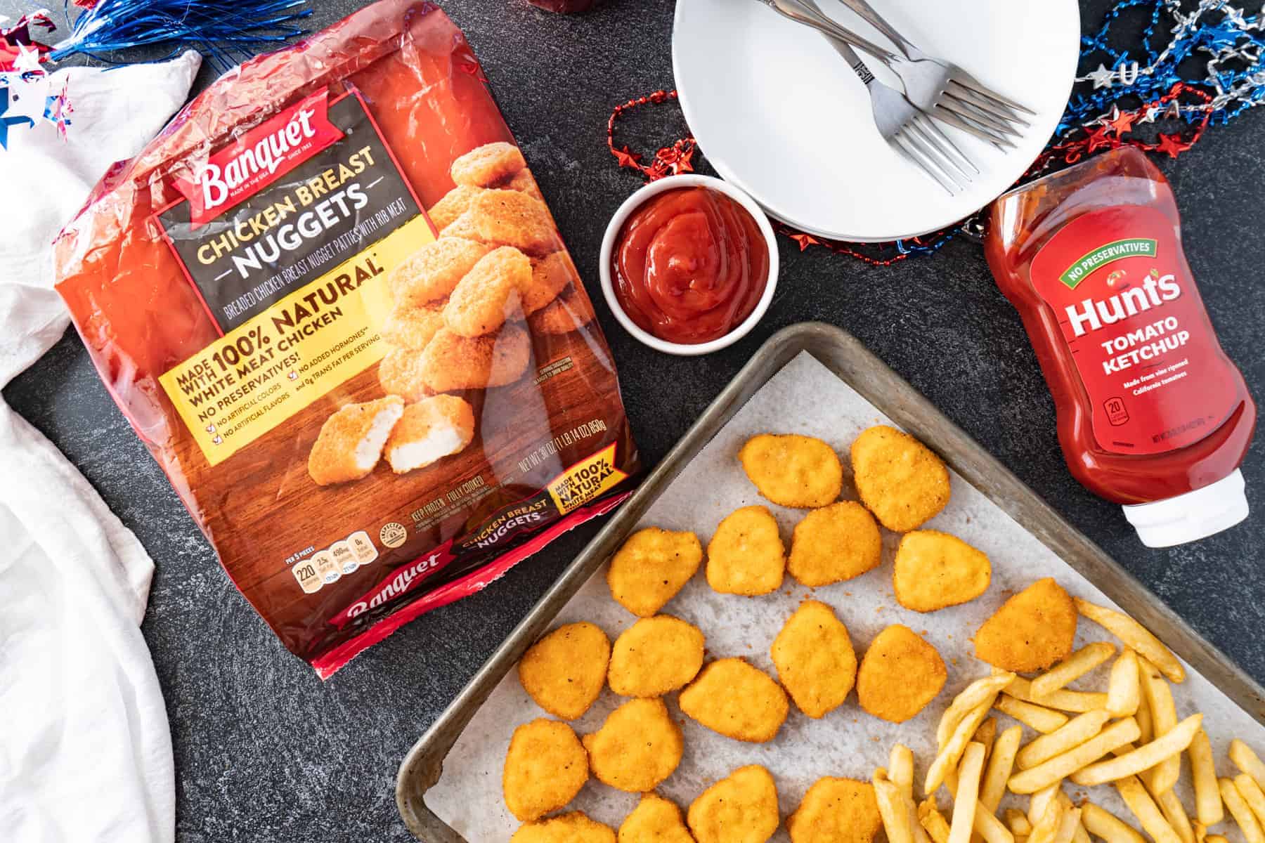 chicken nuggets on tray with ketchup bottle and chicken nugget bag nearby