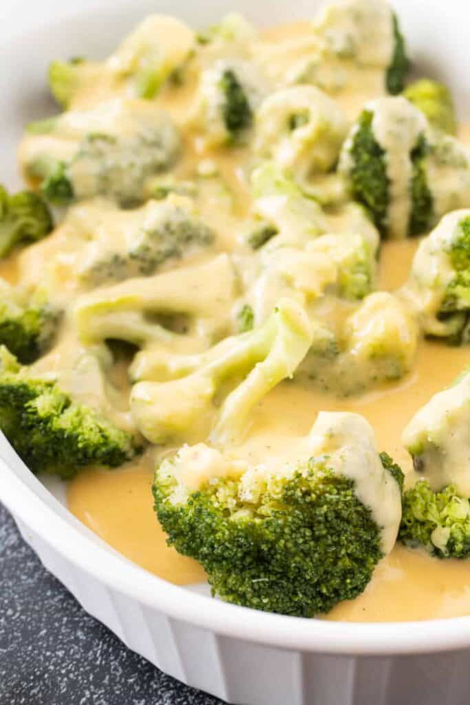 close up of broccoli covered in cheese