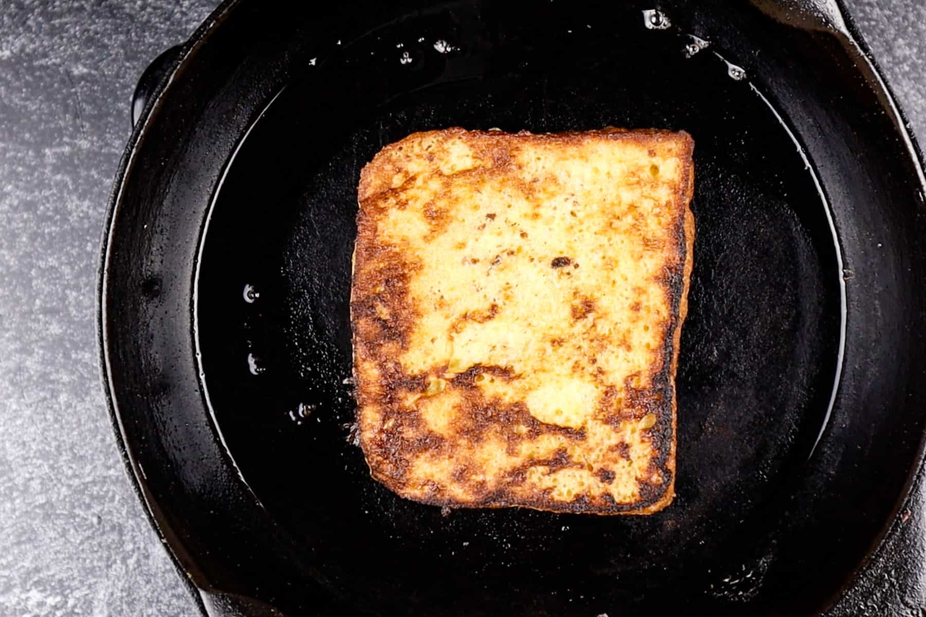 french toast in frying pan cooked to golden brown