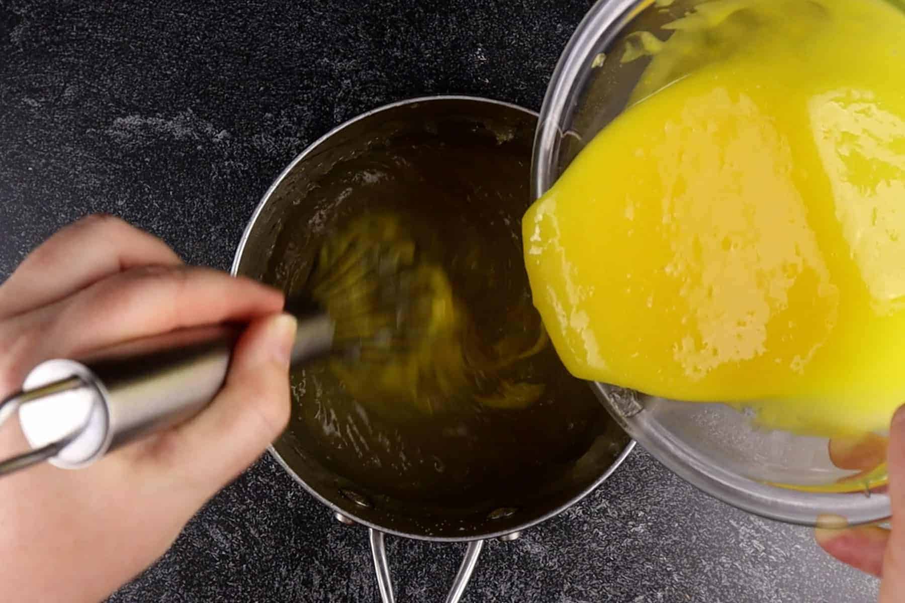 adding tempered yolks to lemon filling
