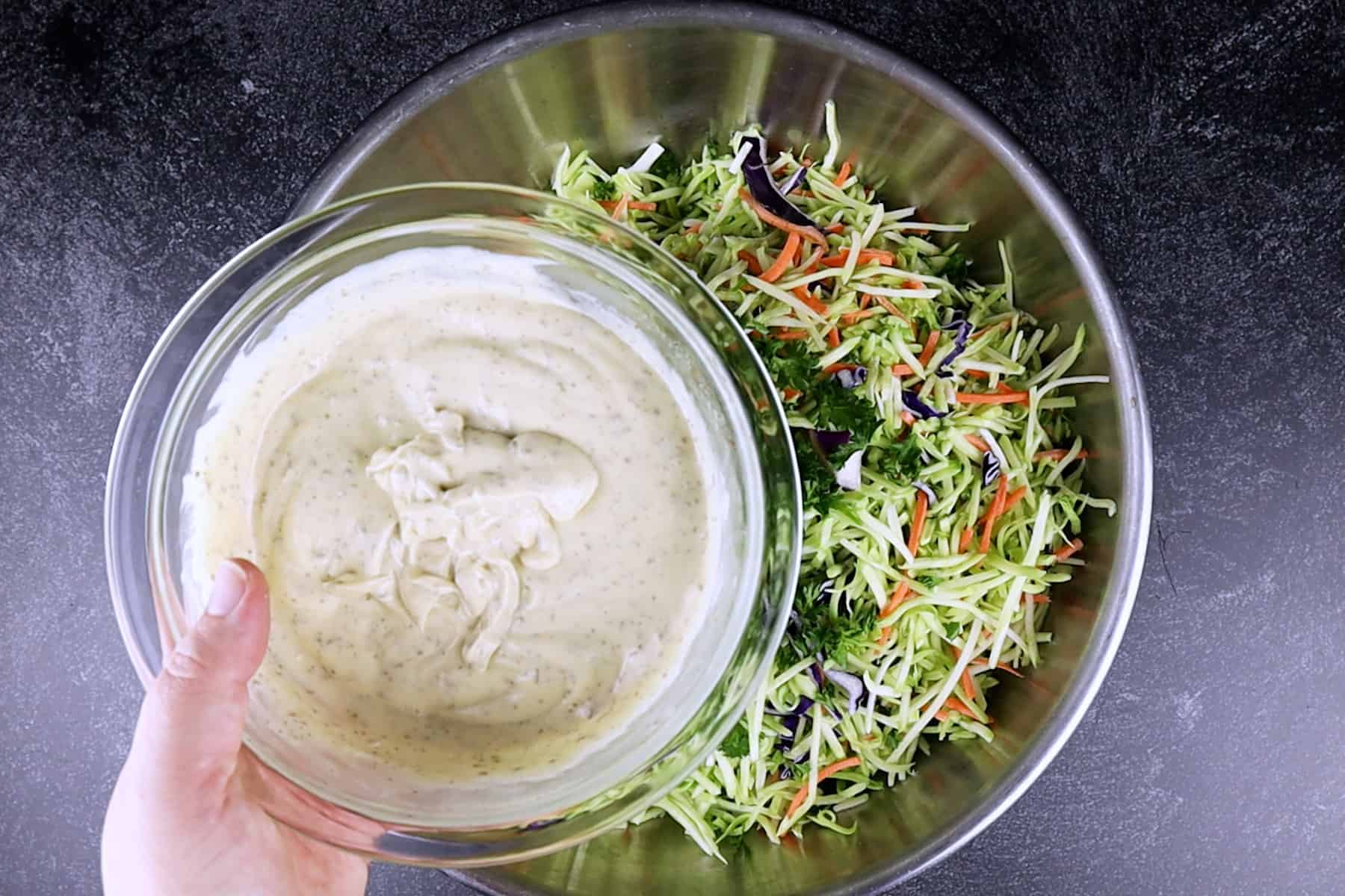 adding dressing to broccoli slaw