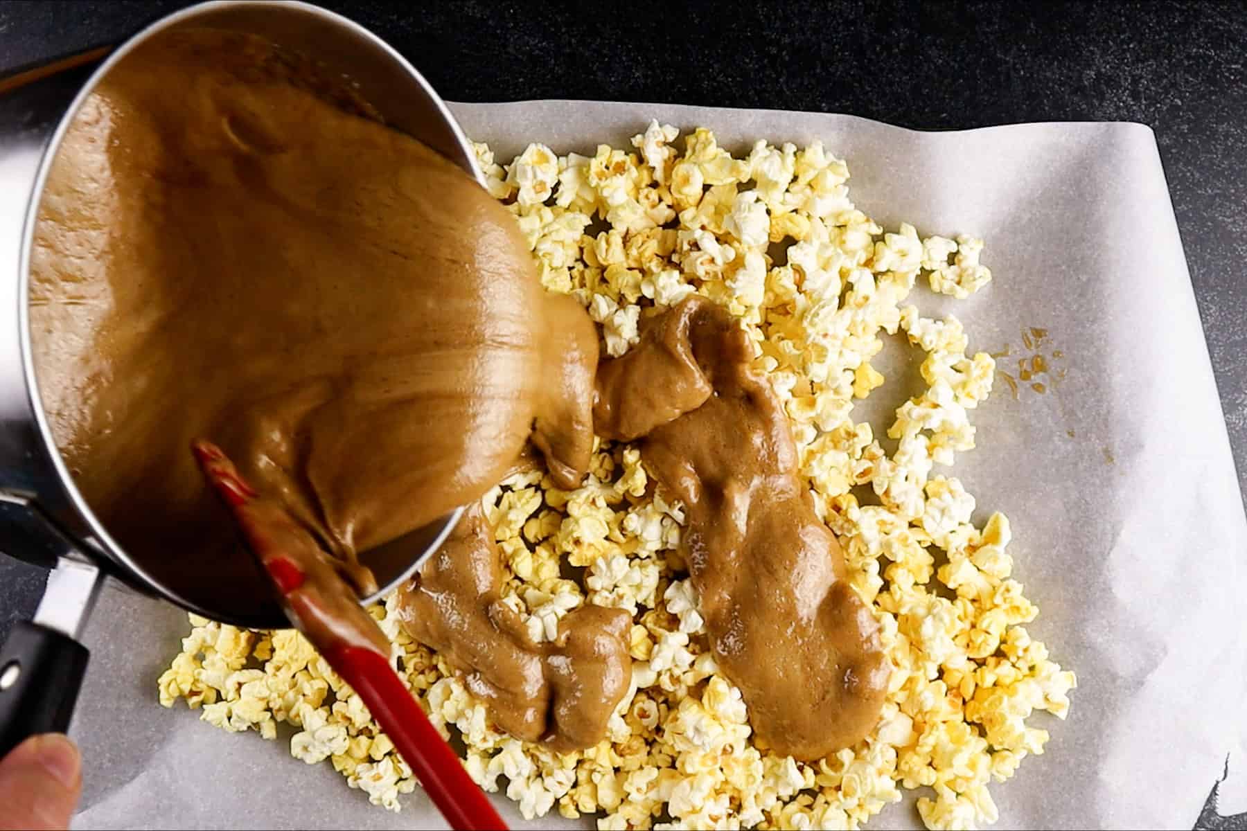 pouring caramel over popcorn