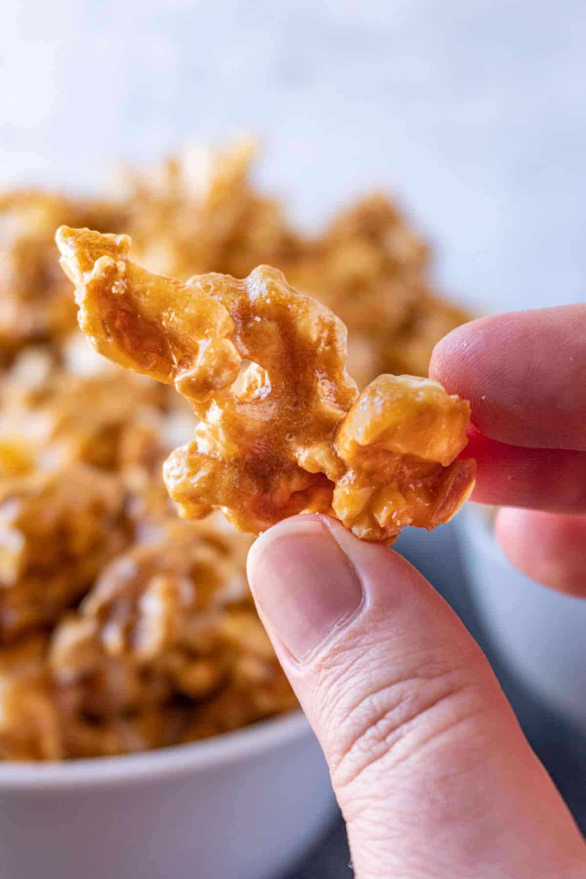 close up of caramel popcorn being held