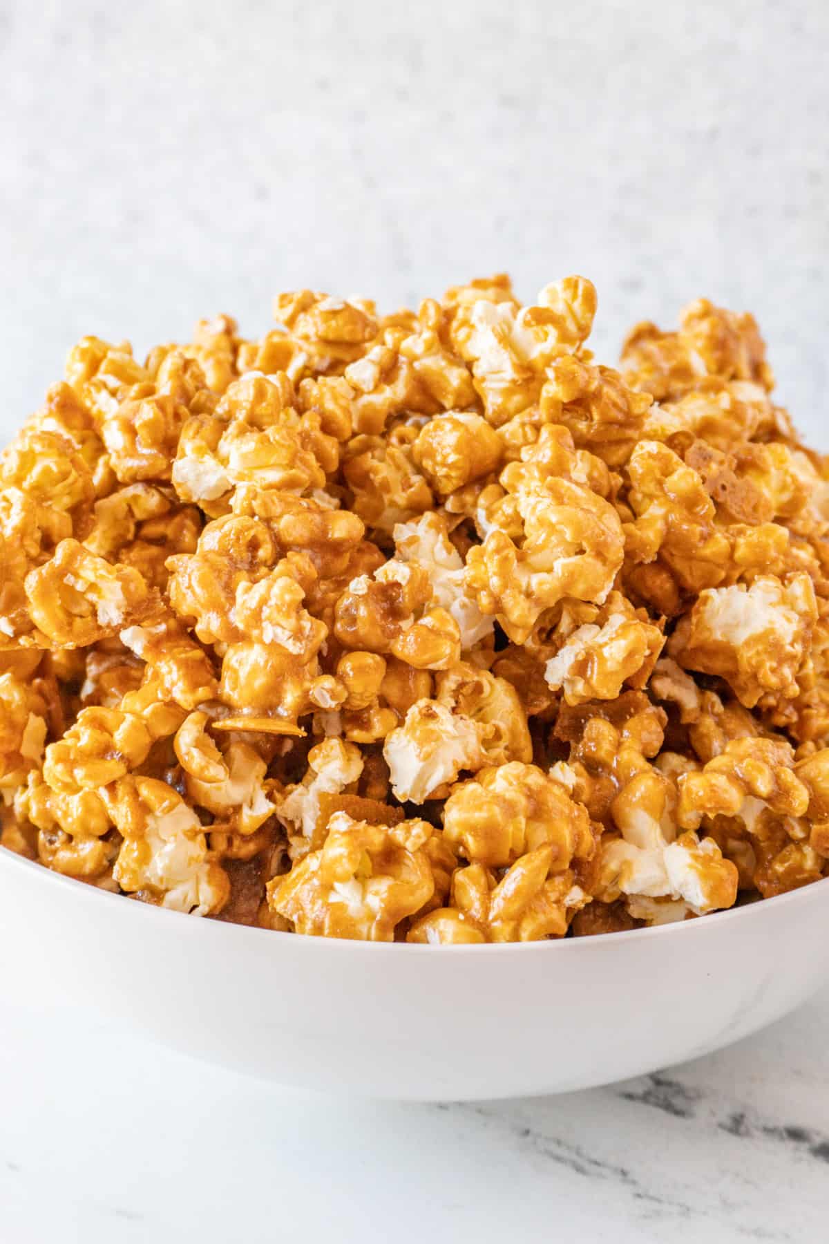 caramel popcorn piled high in large white bowl