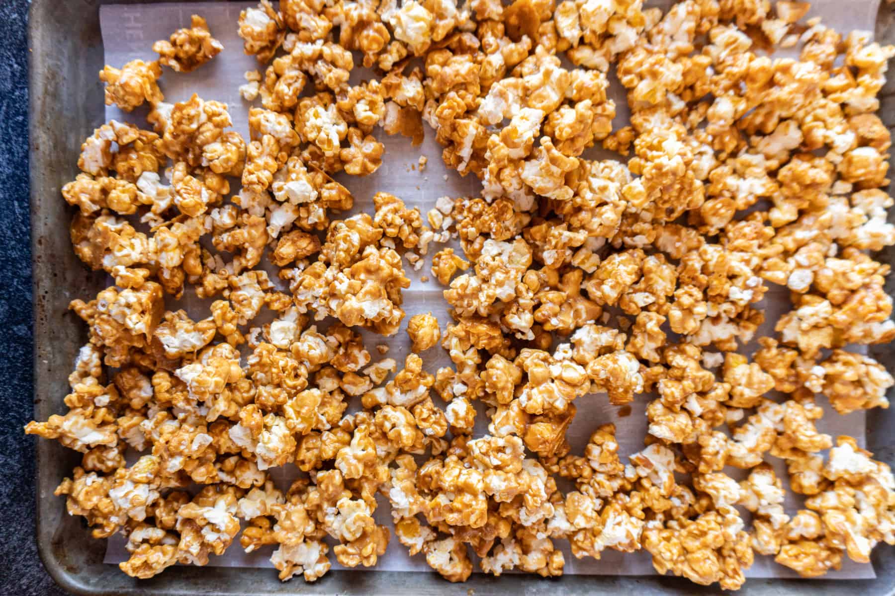 caramel popcorn after being baked on baking sheet