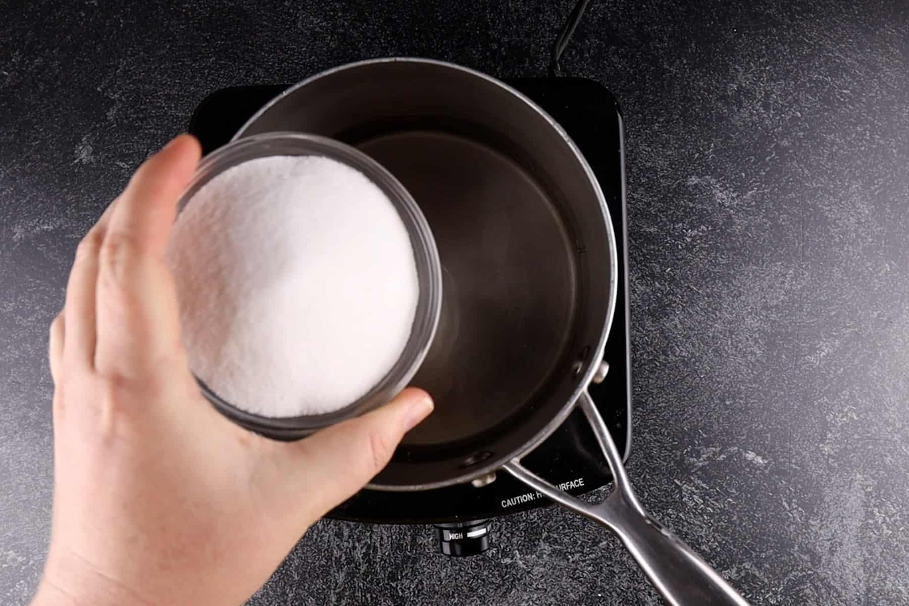 adding sugar to saucepan