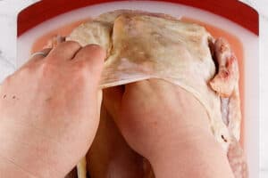 separating the skin from the breast of the turkey