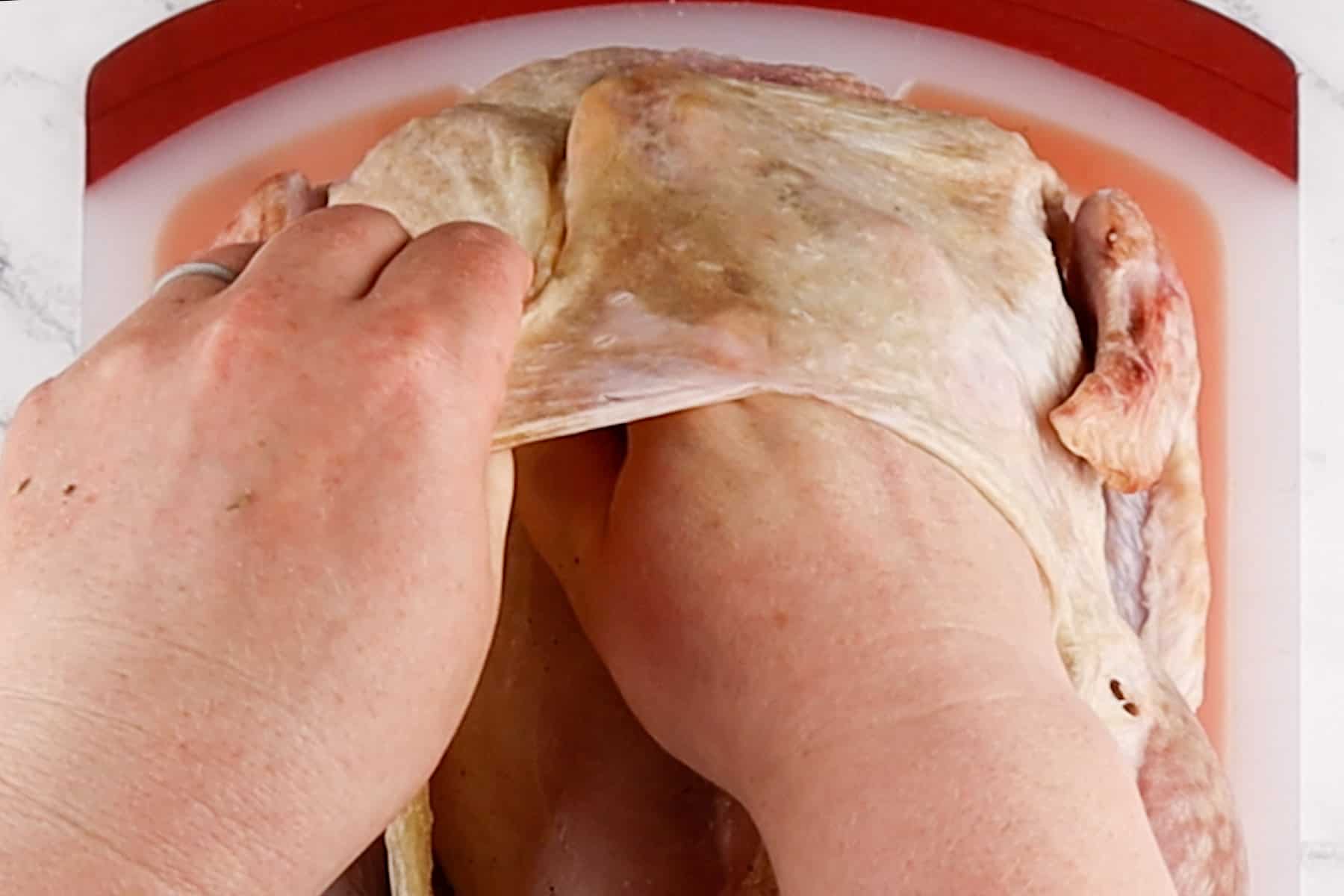 separating the skin from the breast of the turkey